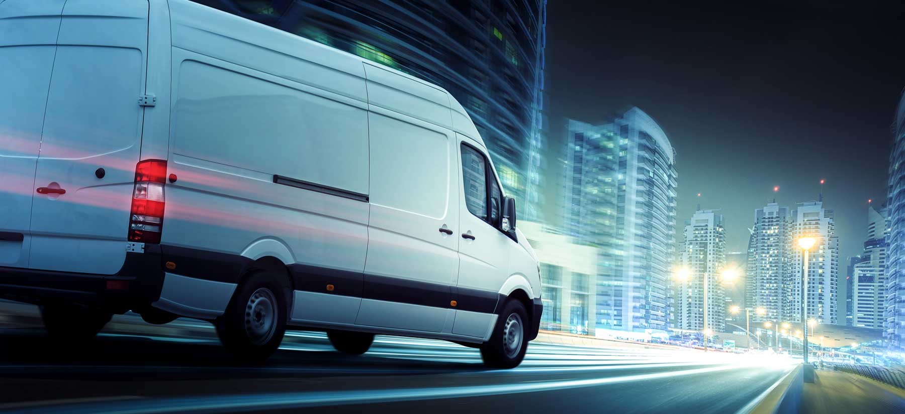 delivery van driving down a busy highway at night