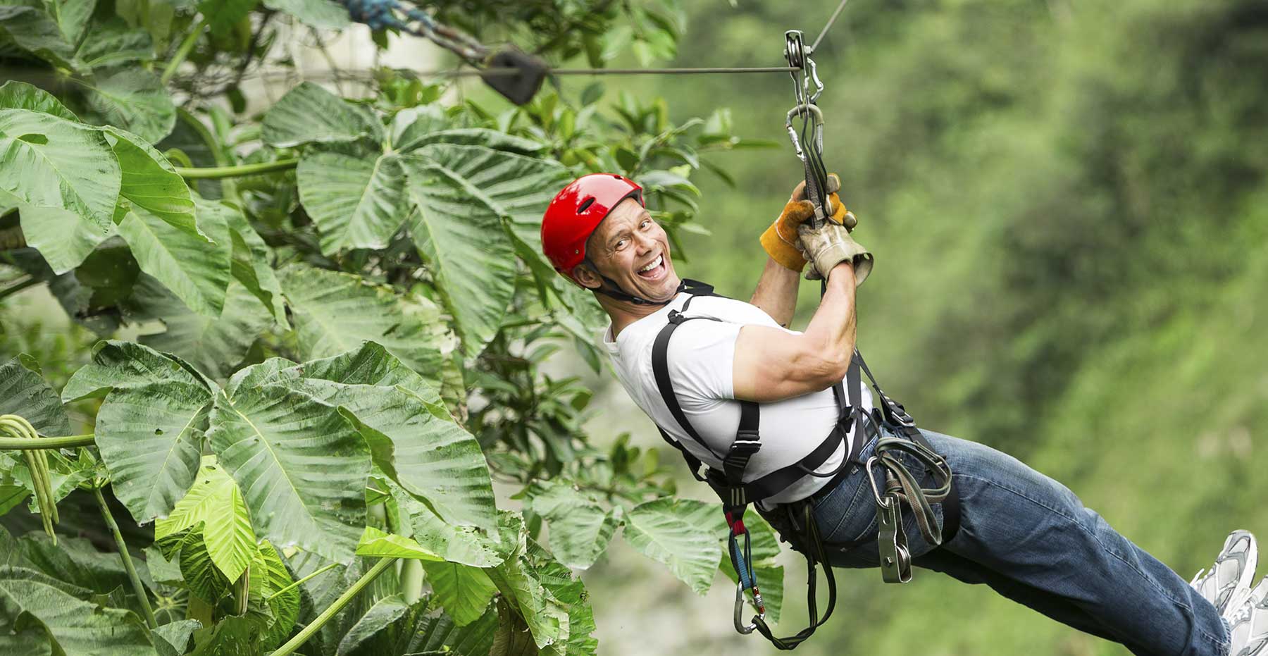 man hanging on a zip line