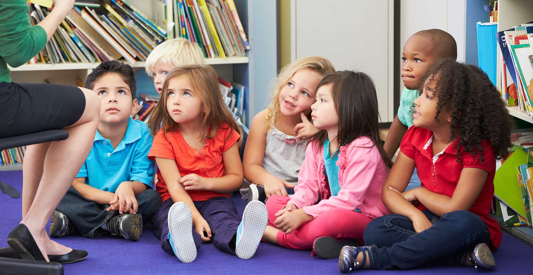 aerial view of children sitting on the floor listening to a fairy tale