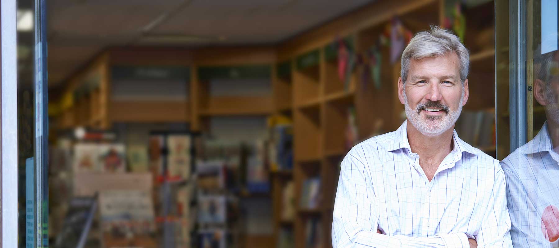 man standing in open doorway of business