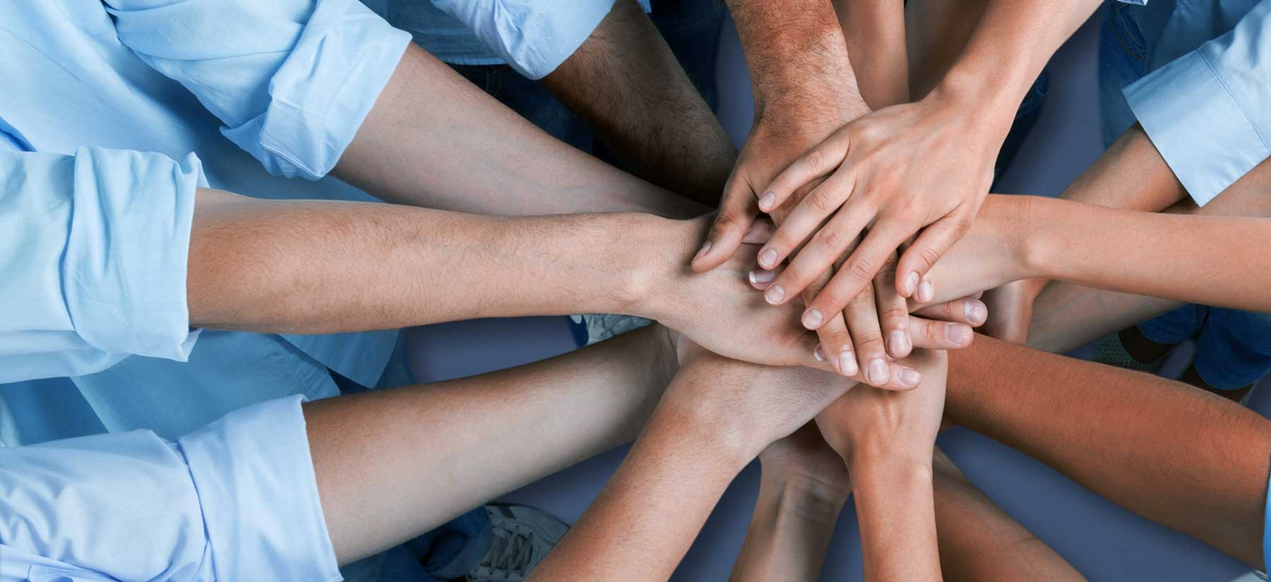 several people's hands stacked on top of each other'