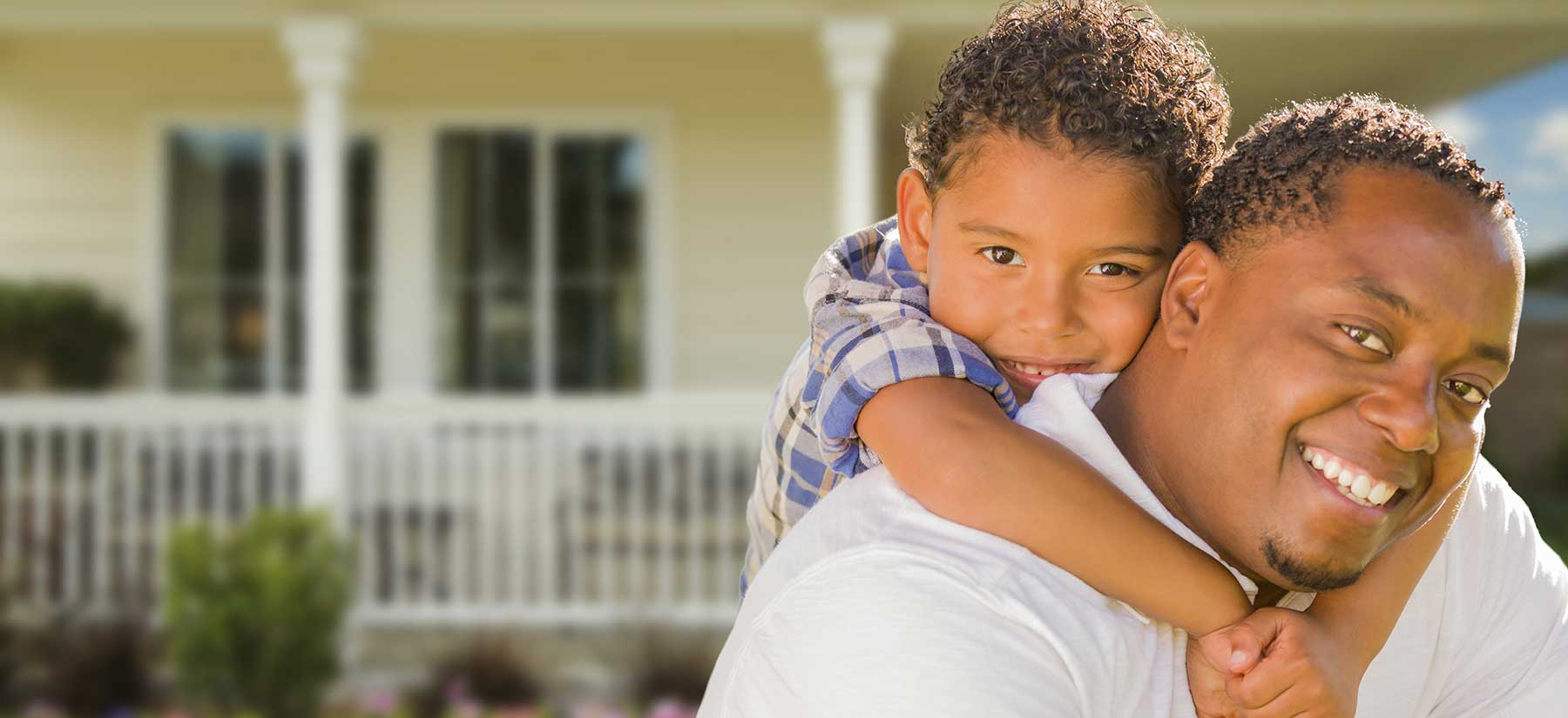 father and son in front of a house