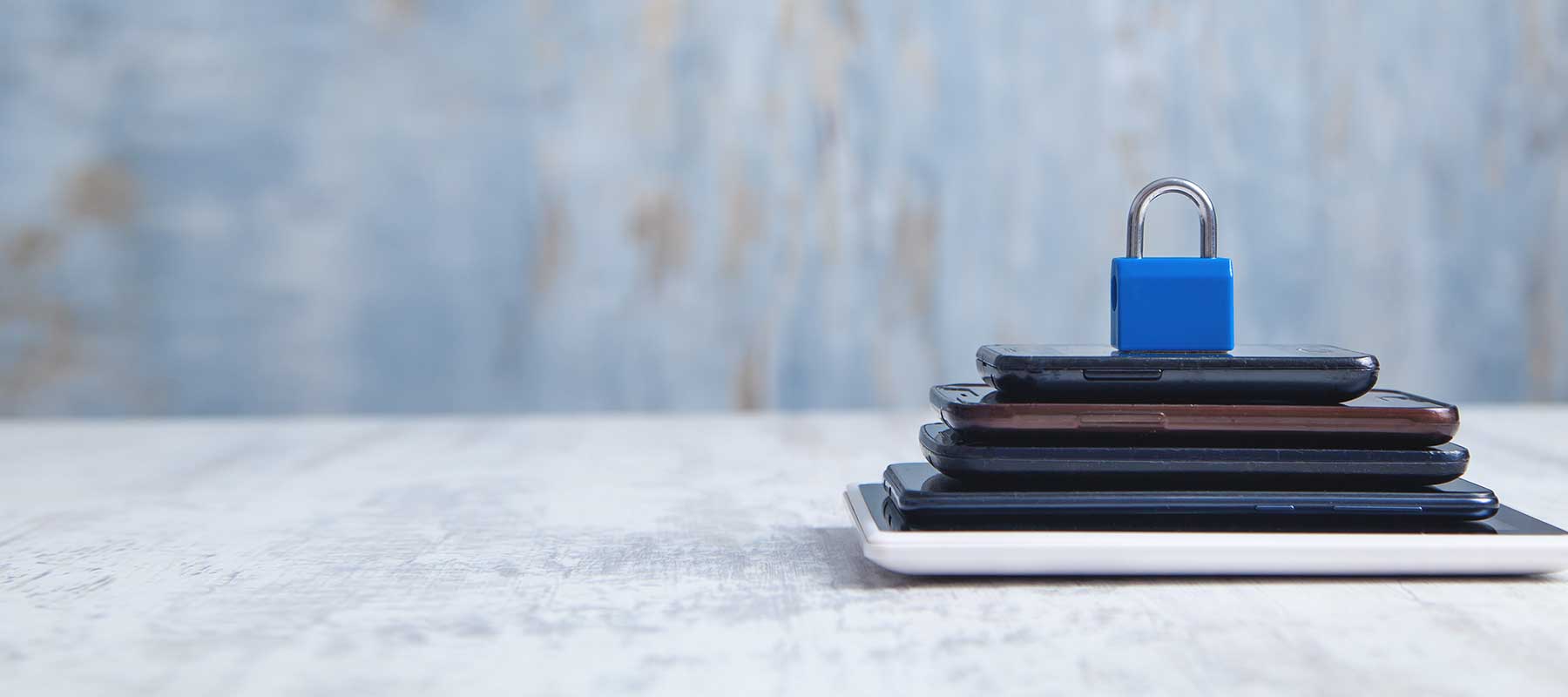 padlock sitting on top of stack of smart devices