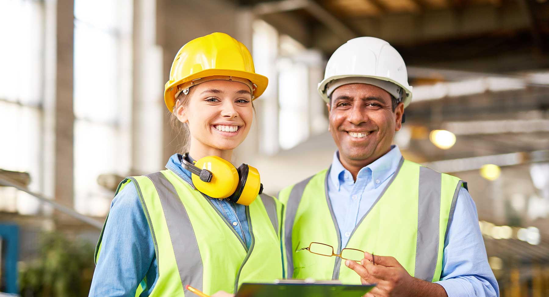 man and woman smiling while wearing safety gear