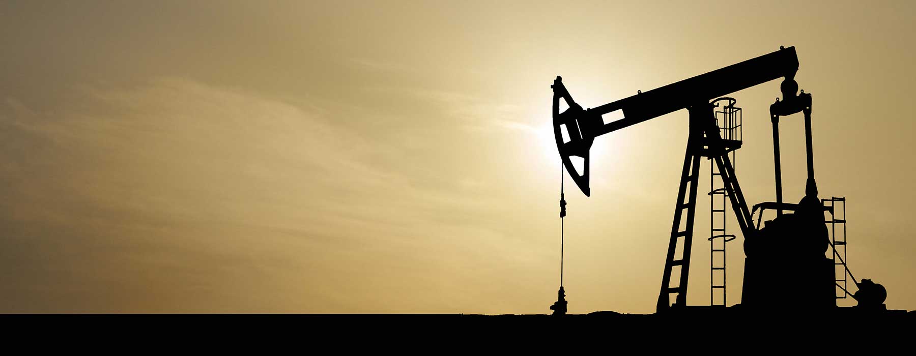 oilfield pump jack in front of sunset